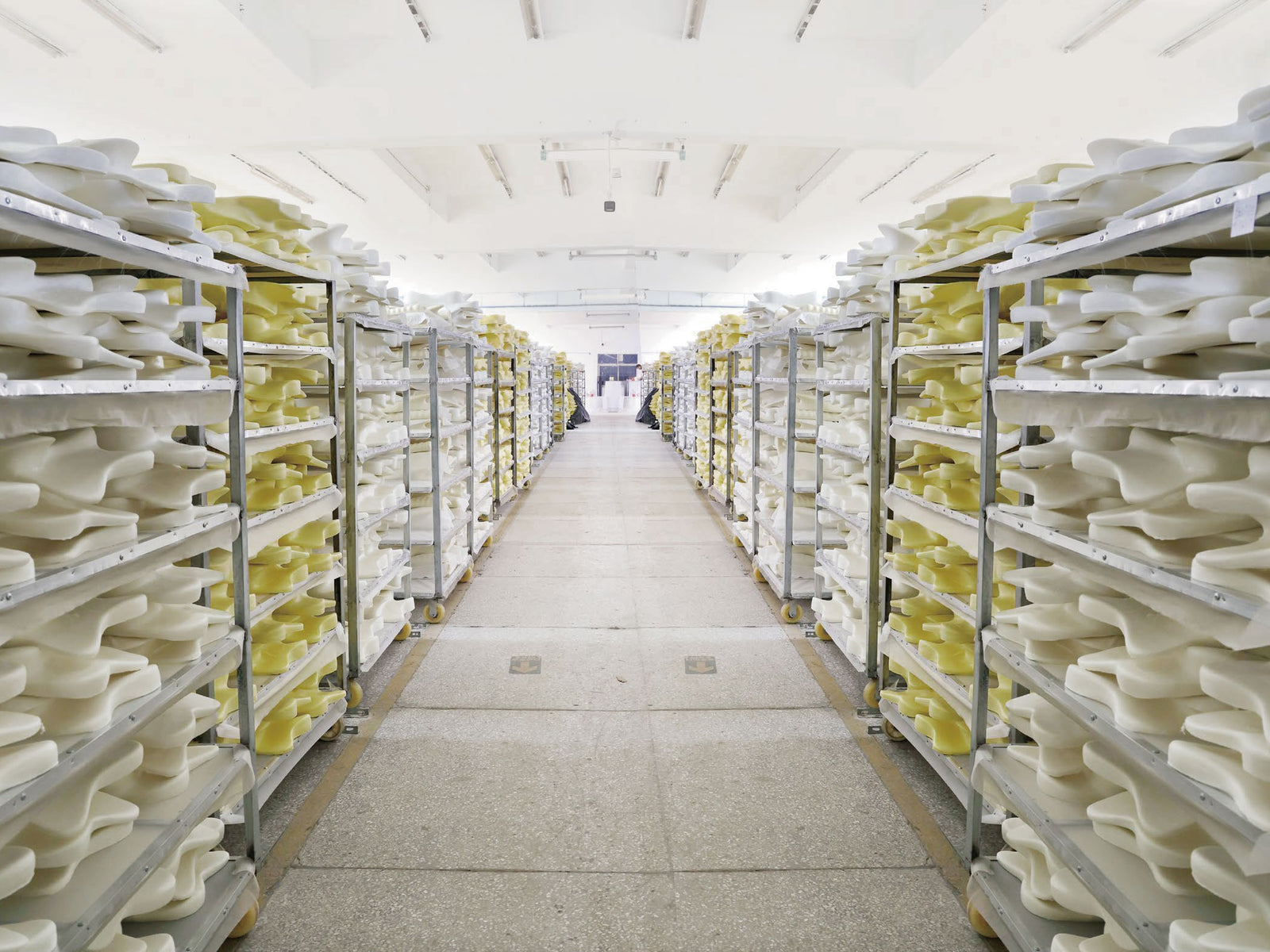 Rows of shaped foam pillow cores organised on storage racks